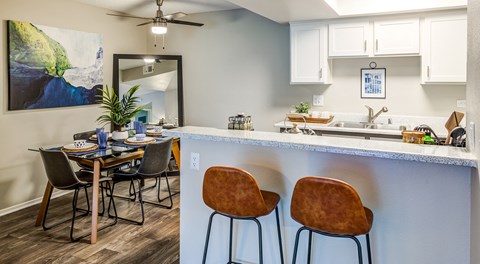 A kitchen with a dining table and chairs.