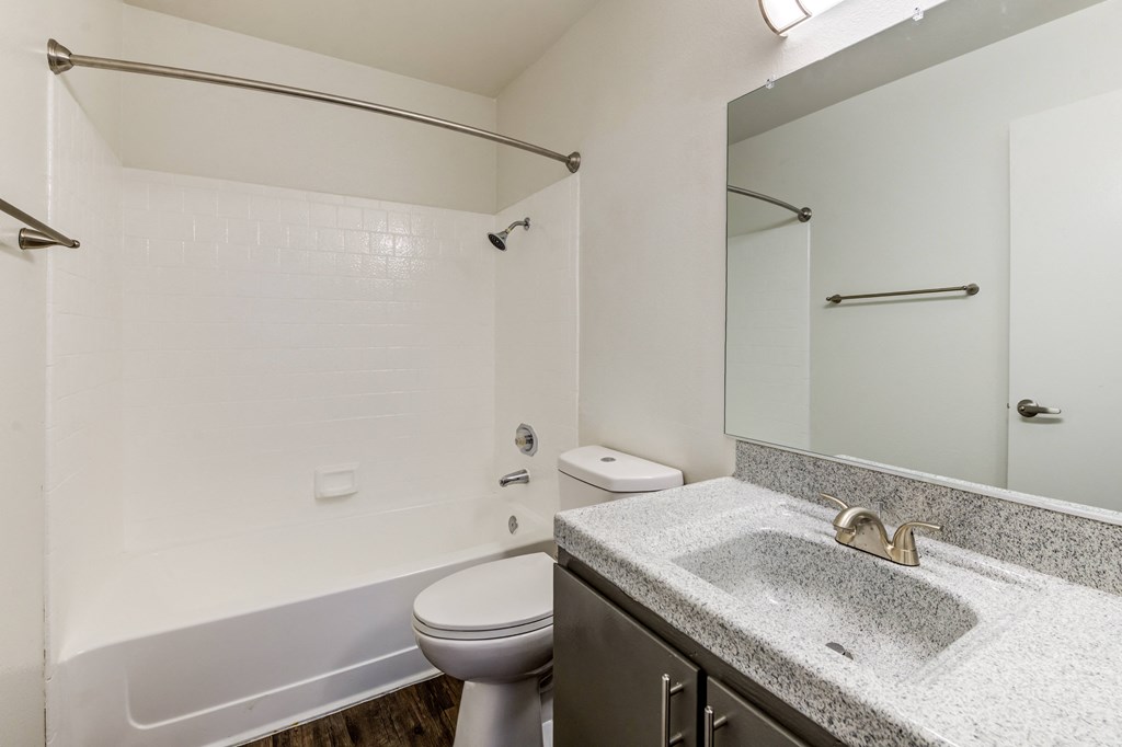 A bathroom with a toilet, sink, and shower.