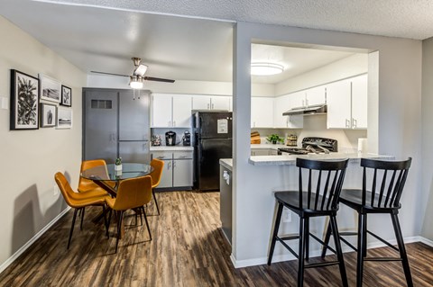 A kitchen with a dining table and chairs.