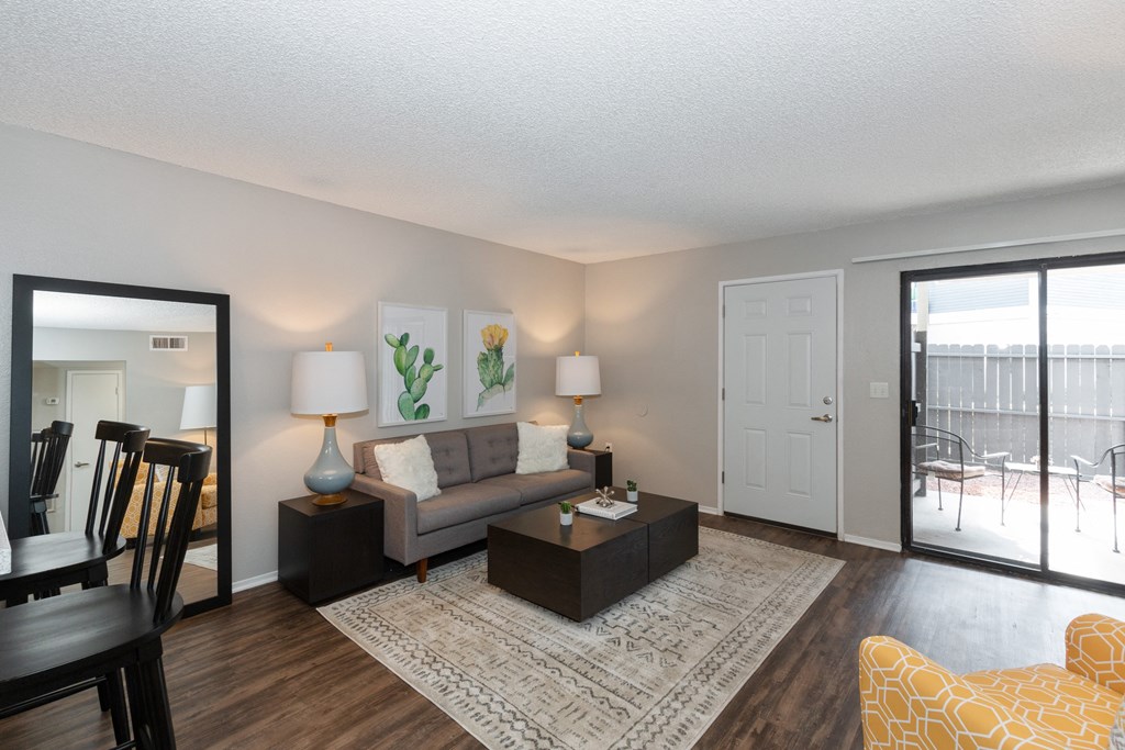 A living room with a grey couch, a yellow chair, and a white door.