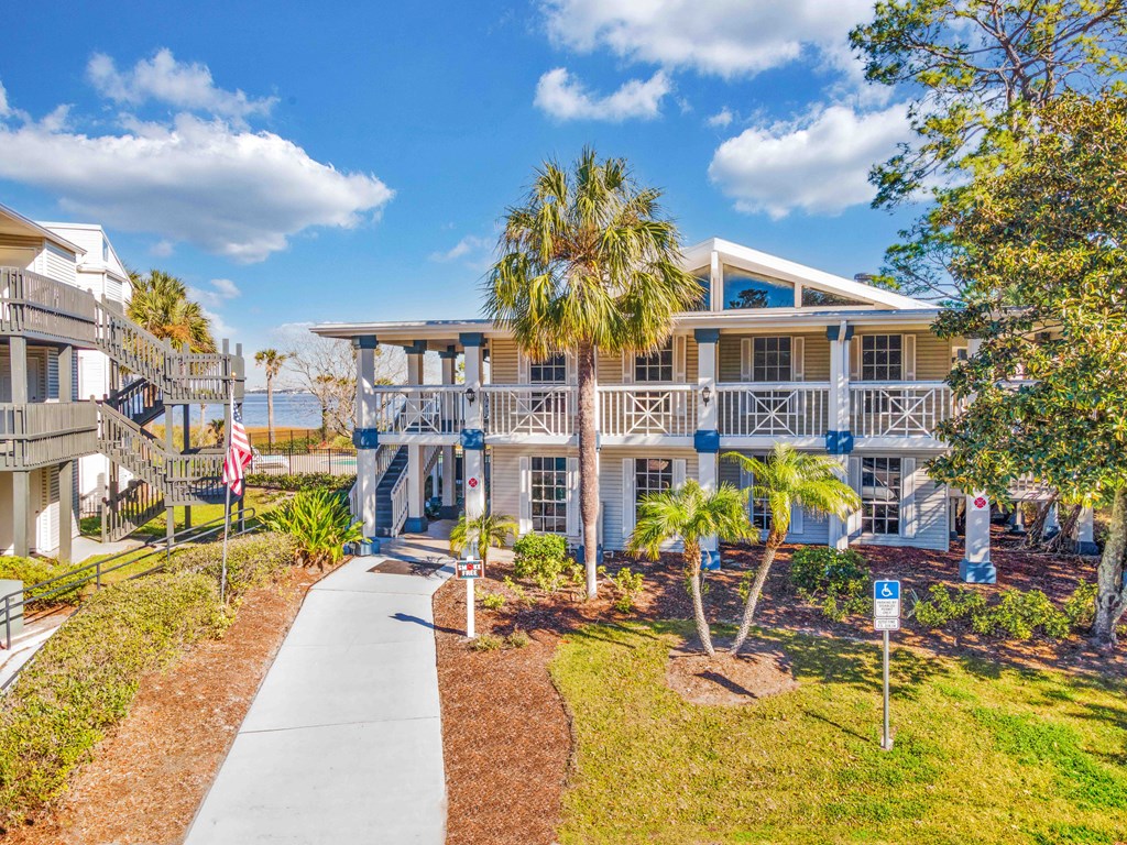 a house with palm trees in front of it and a sidewalk