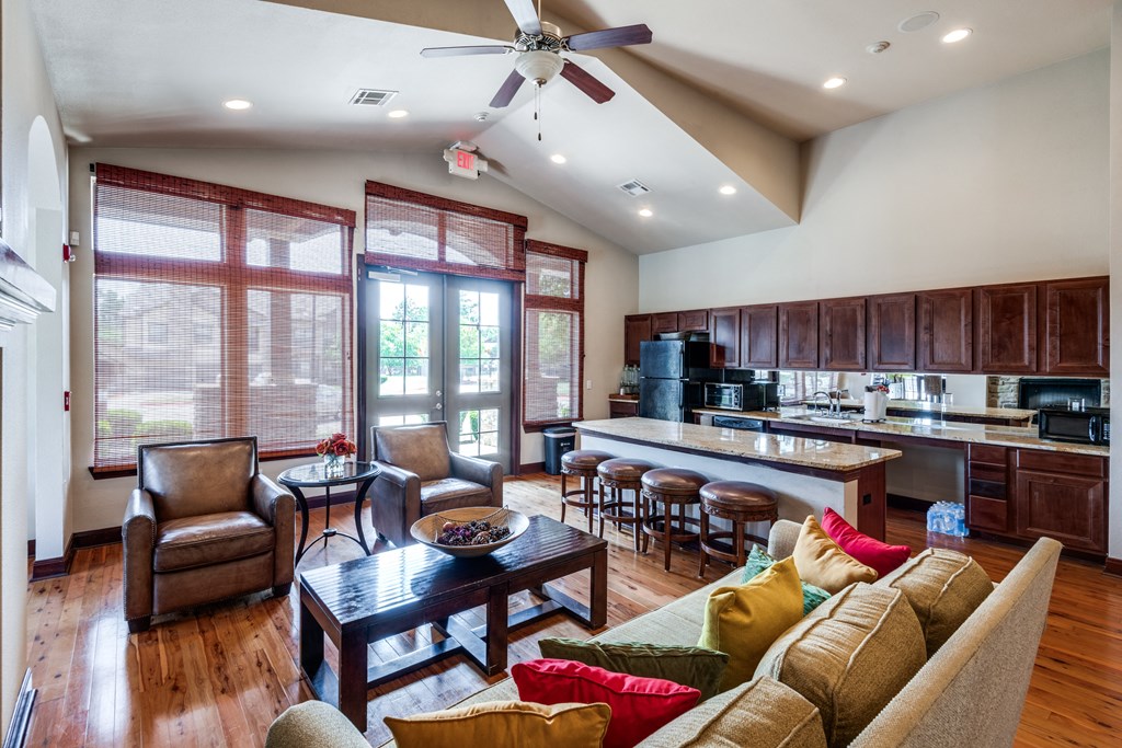 a large living room with a kitchen and a ceiling fan