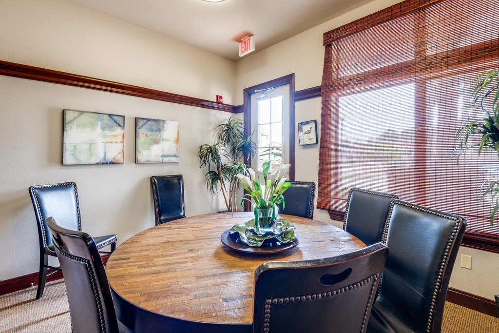 a dining room with a wooden table and leather chairs