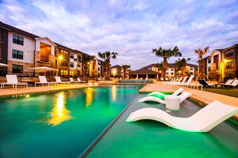A swimming pool with a greenish tint and a white design on the side.