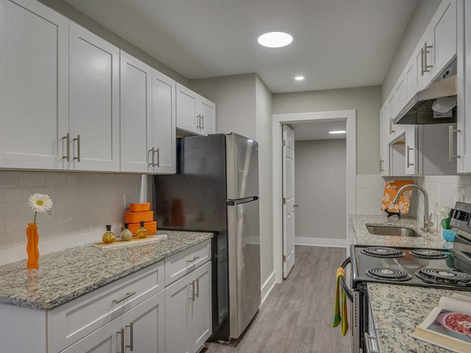 a kitchen with white cabinets and a stainless steel refrigerator