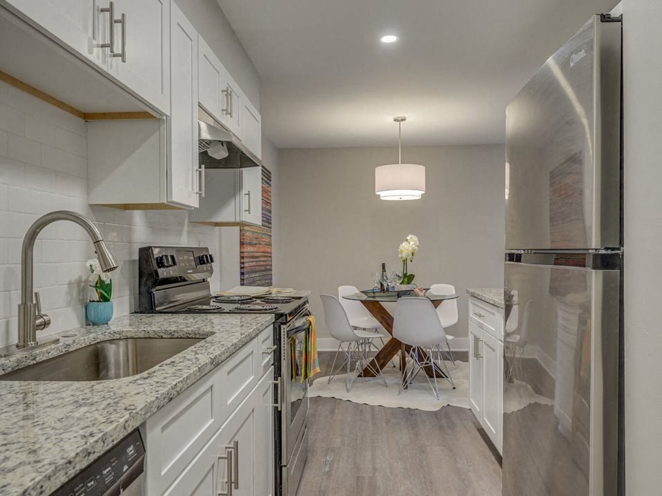 a kitchen with a sink and a table with chairs