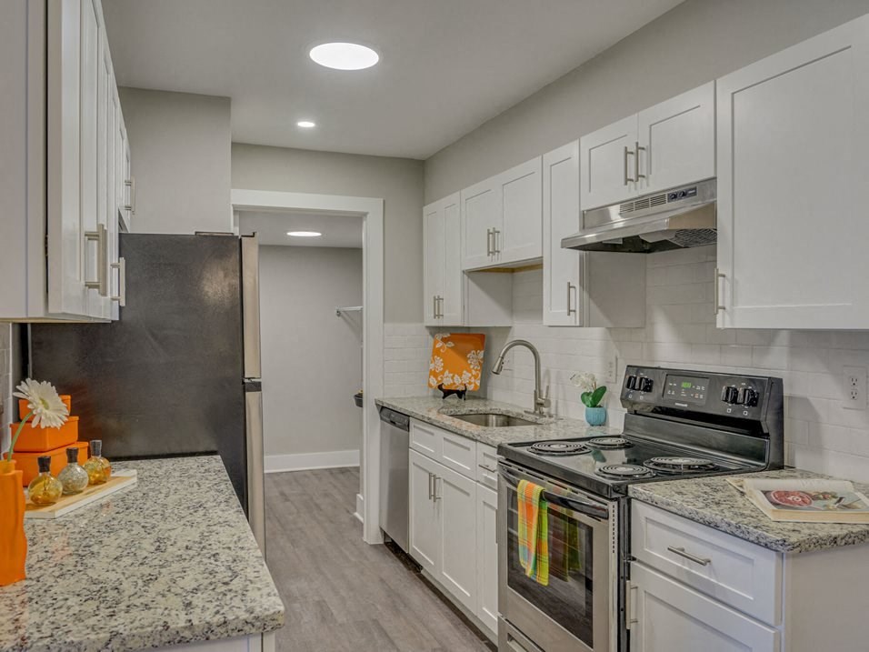a kitchen with white cabinets and stainless steel appliances