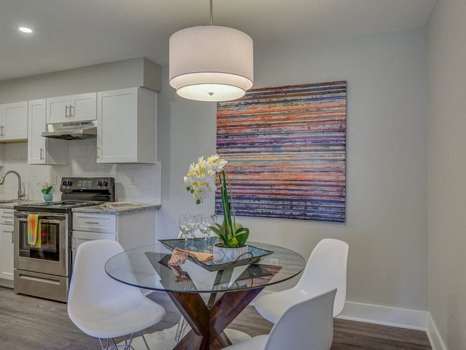 a kitchen and dining room with a glass table and chairs