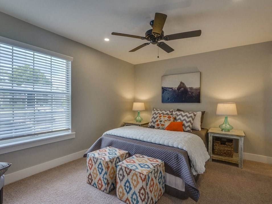 a bedroom with a bed and a ceiling fan