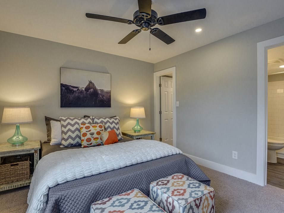 a bedroom with a bed and a ceiling fan
