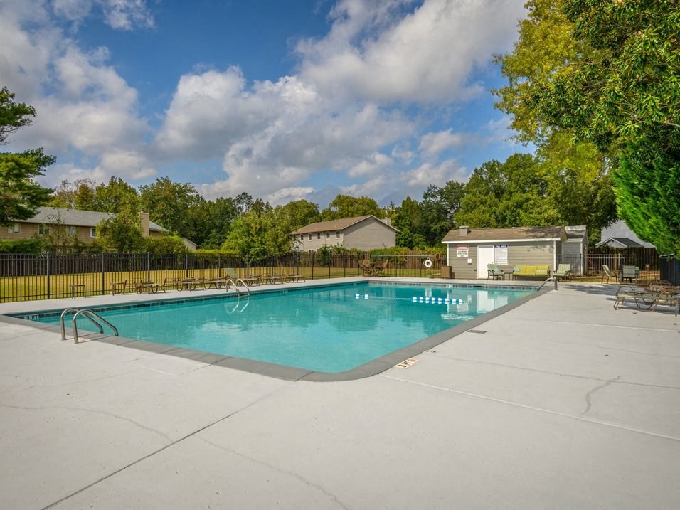 a swimming pool with trees and a fence around it