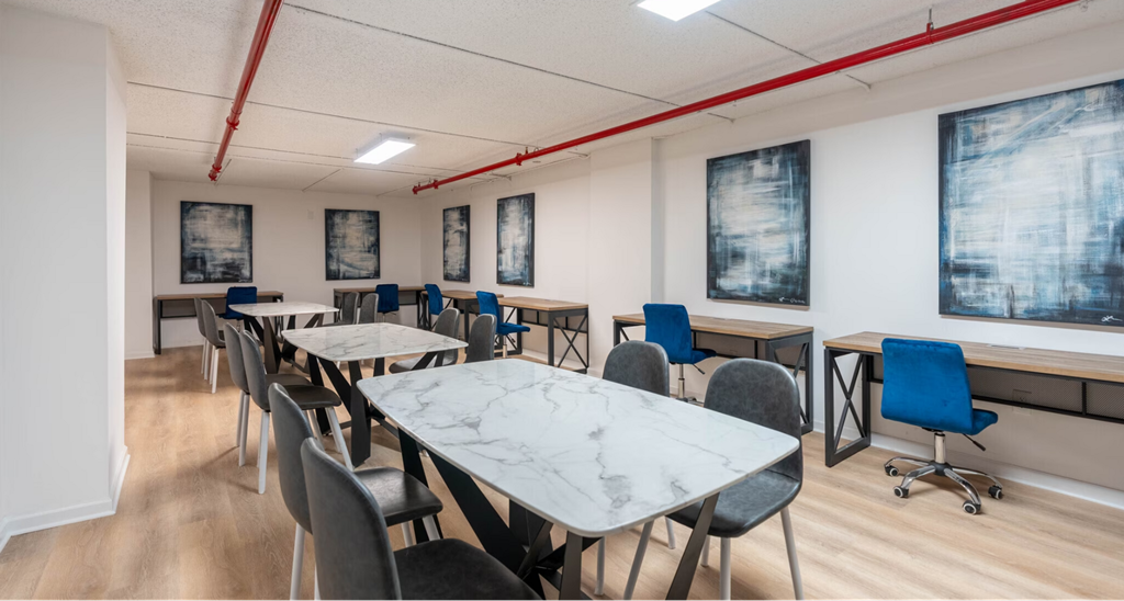 a dining room with tables and chairs and paintings on the wall