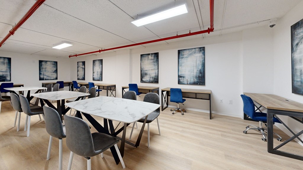 a dining room with tables and chairs and paintings on the wall