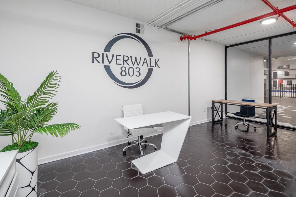 an office with a white desk and a riverwalk logo on the wall