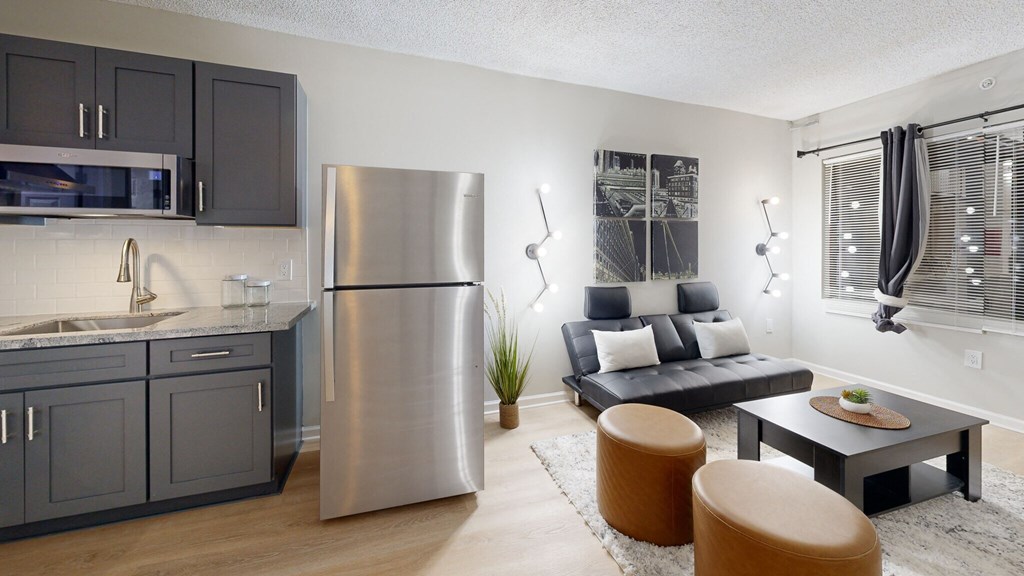 a kitchen and living room with a stainless steel refrigerator