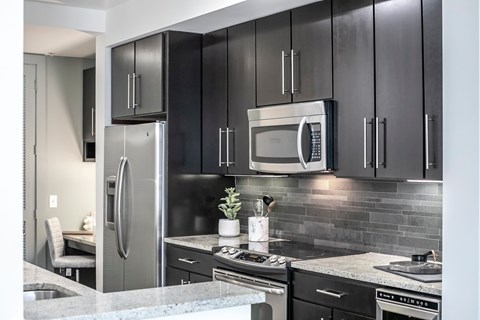 A modern kitchen with a stainless steel refrigerator and microwave.