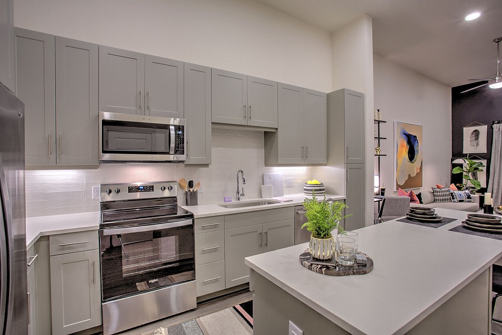 A modern kitchen with a stainless steel refrigerator and oven.