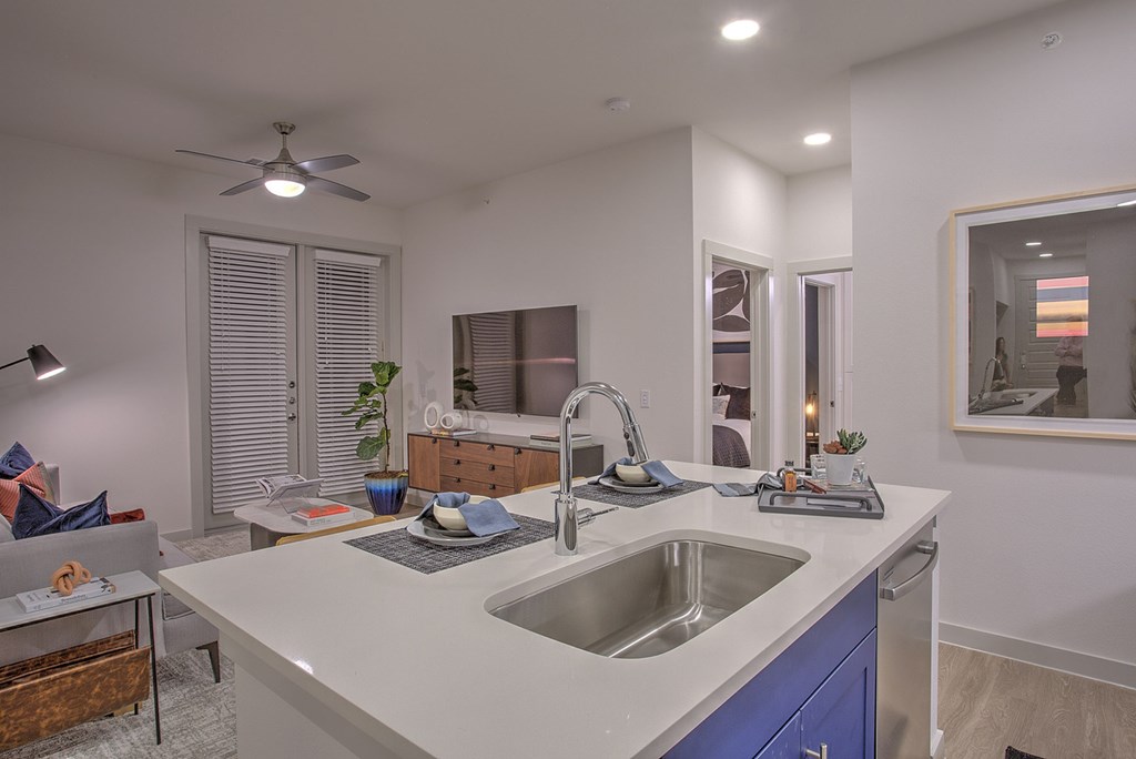 A modern kitchen with a white countertop and blue cabinets.