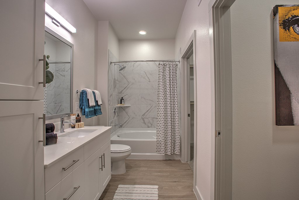 A bathroom with a white counter and a white toilet.
