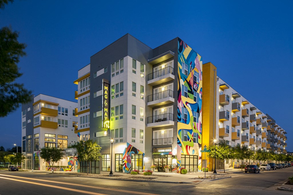 a rendering of a multicolored building on a city street at night