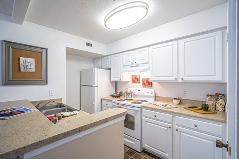 a kitchen with white cabinets and appliances and a counter top