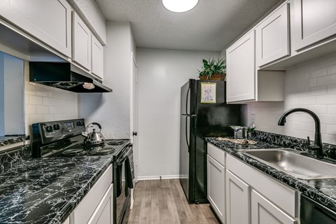 a kitchen with marble counter tops and white cabinets