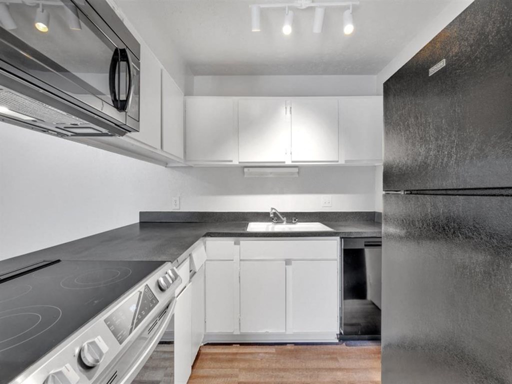 a kitchen with white cabinets and stainless steel appliances