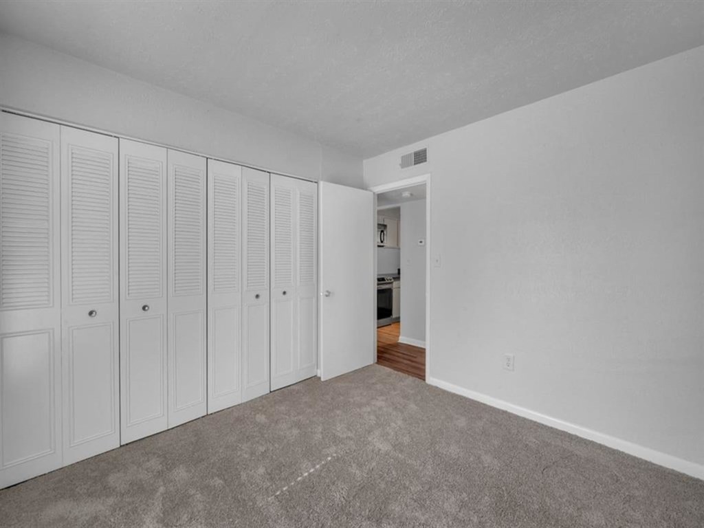 an empty room with white closets on the wall
