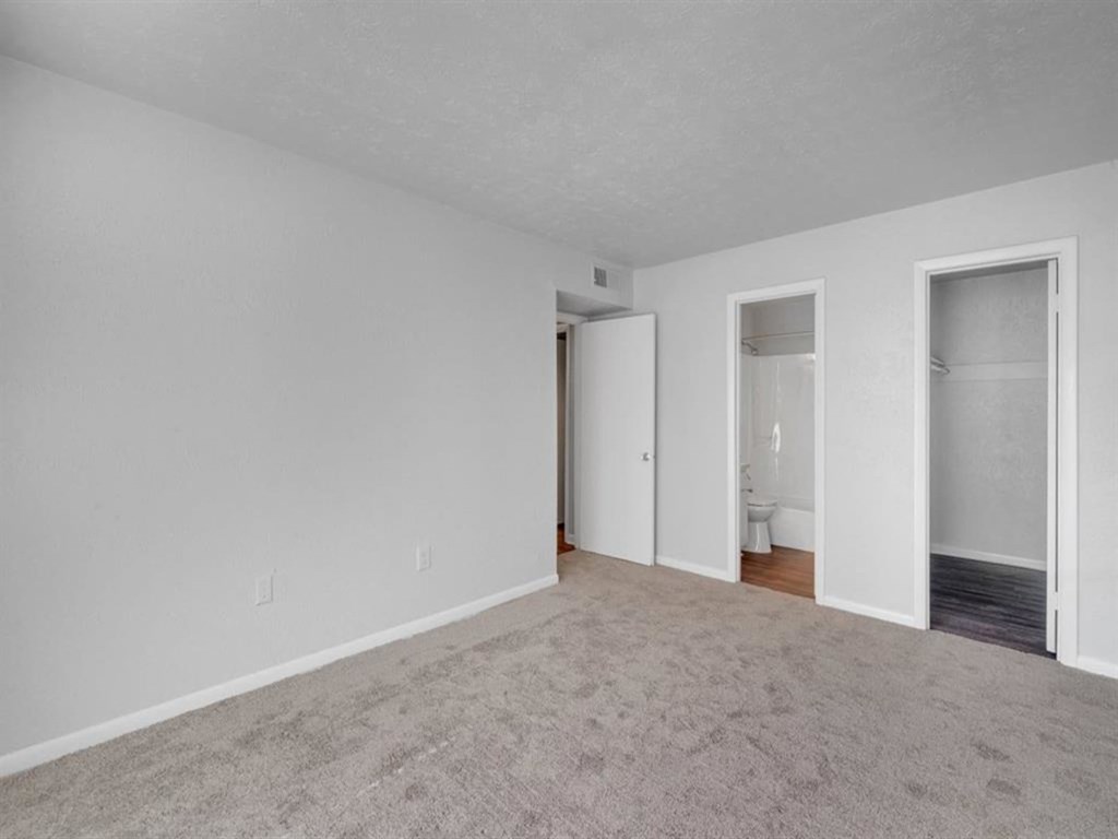 an empty living room with white walls and a carpet