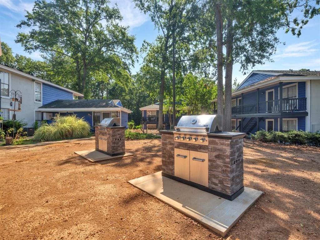 a backyard with a barbecue grill in front of a house