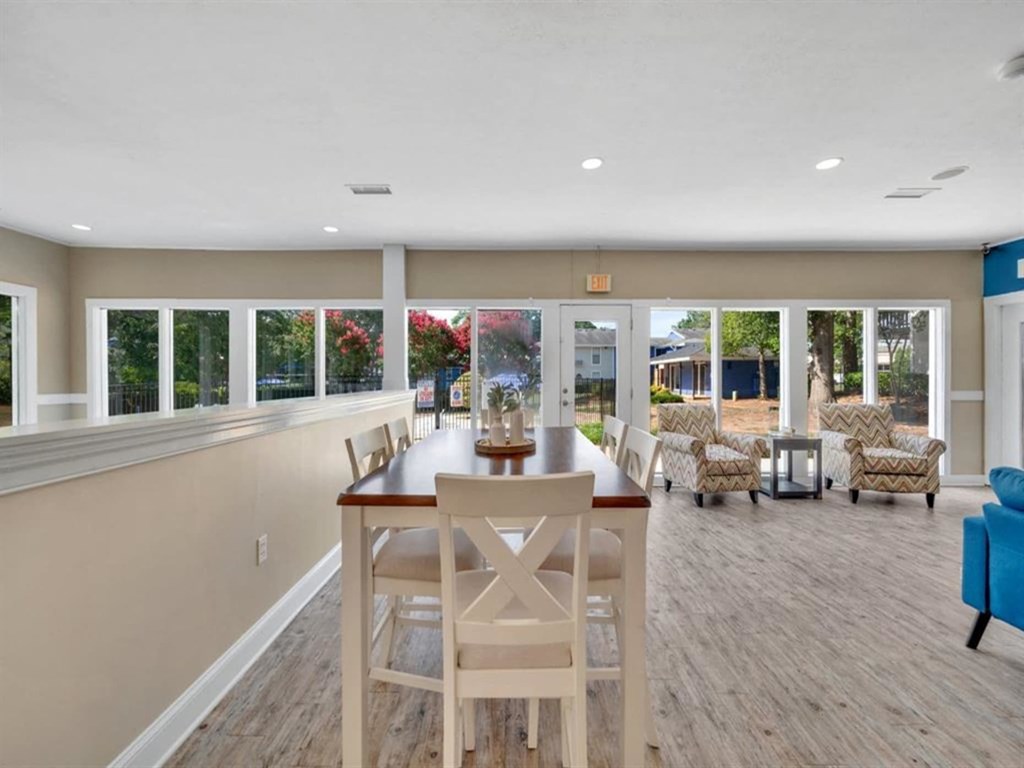 a dining room with a table and chairs in front of windows