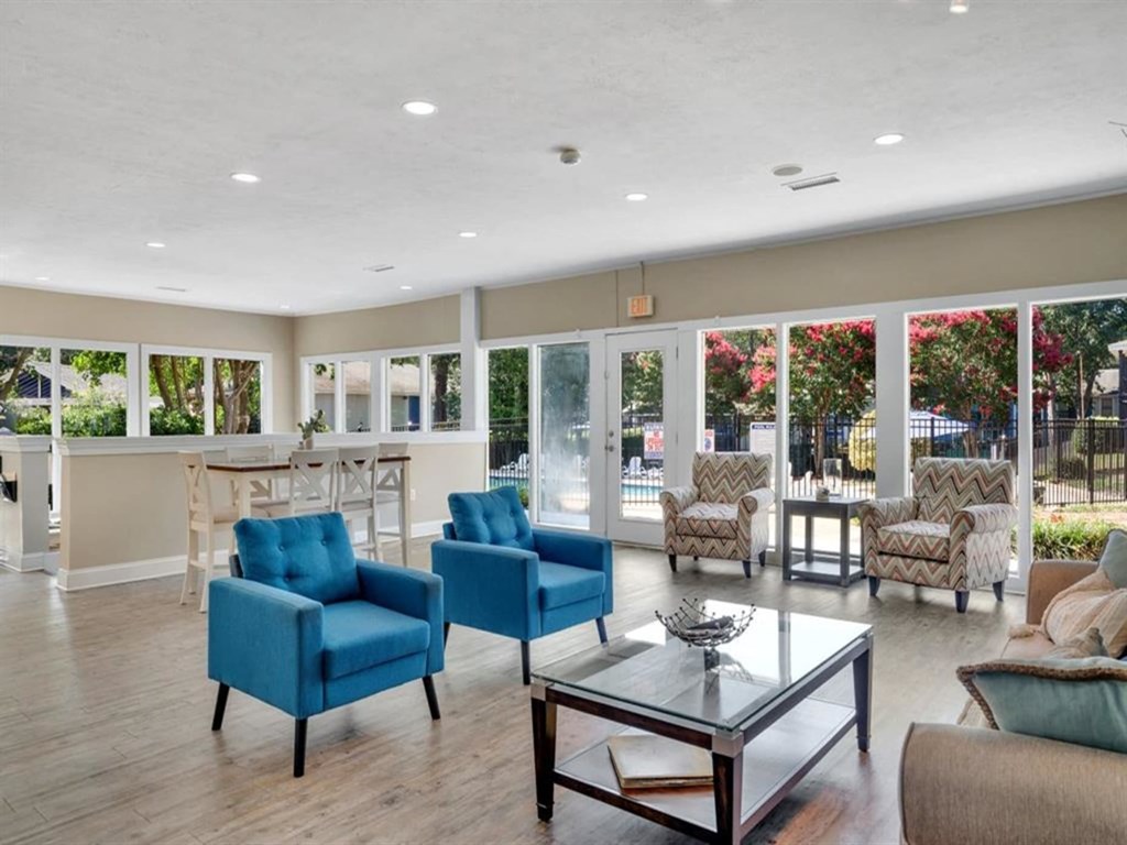 a living room with blue chairs and a glass table
