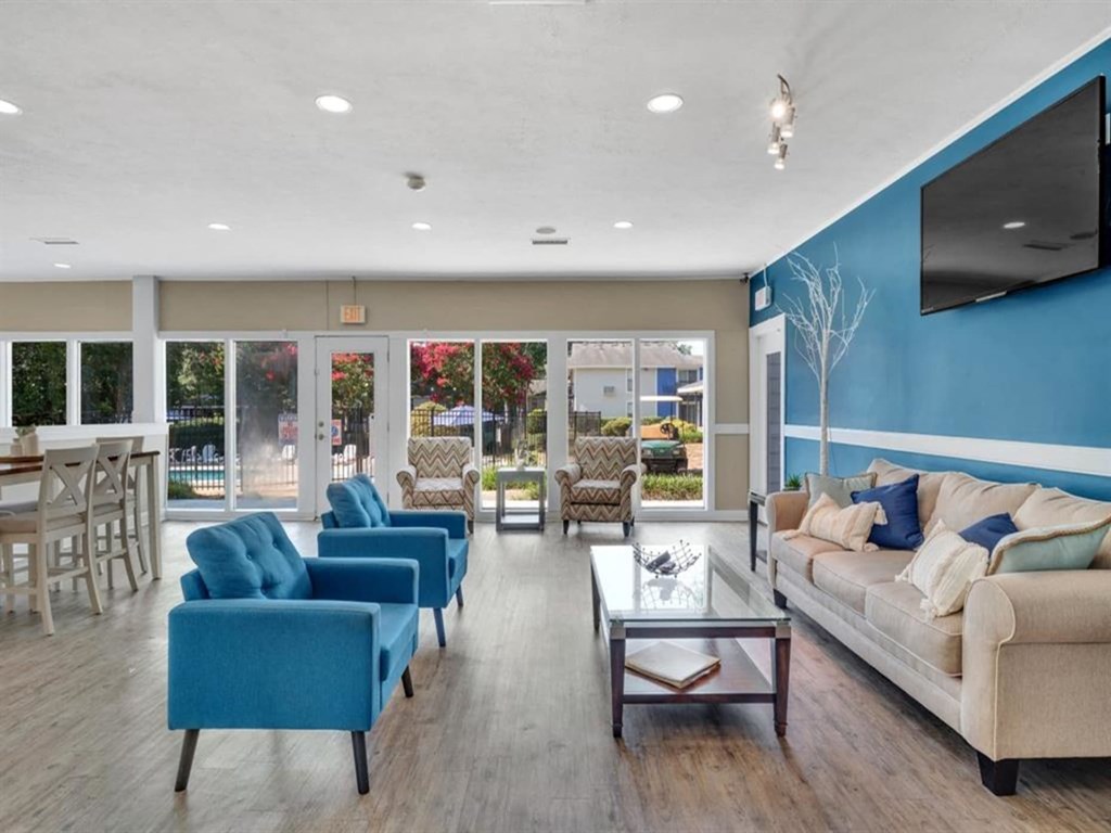 a living room with couches and chairs and a television