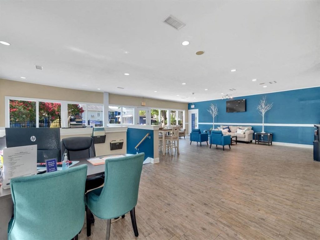 a lounge area with tables and chairs and a tv