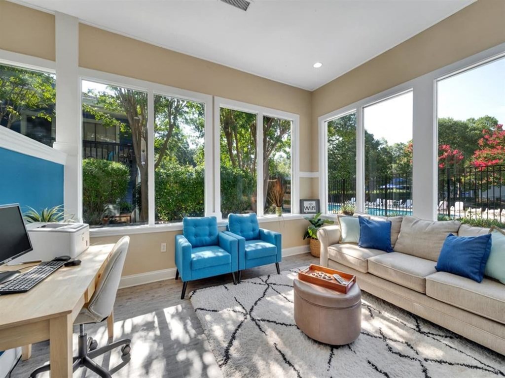 a living room with a couch and chairs and a table with a computer