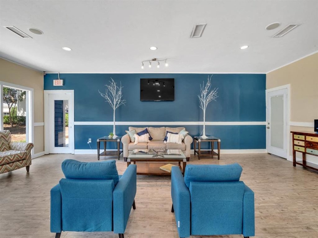 a living room with a blue wall and a couch and chairs