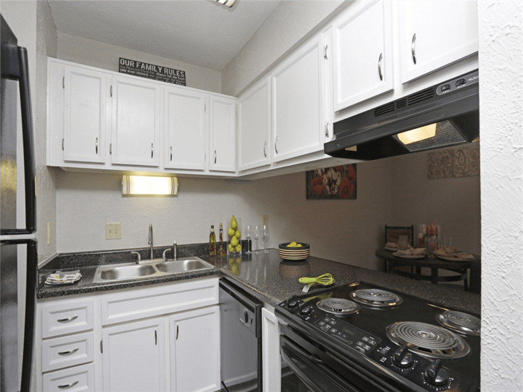 a kitchen with white cabinets and a stove top oven and a sink