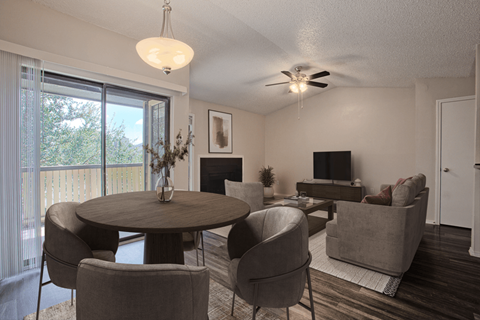 A living room with a round table and grey chairs.