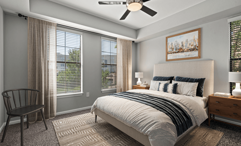 A bedroom with a bed, chair, and window.