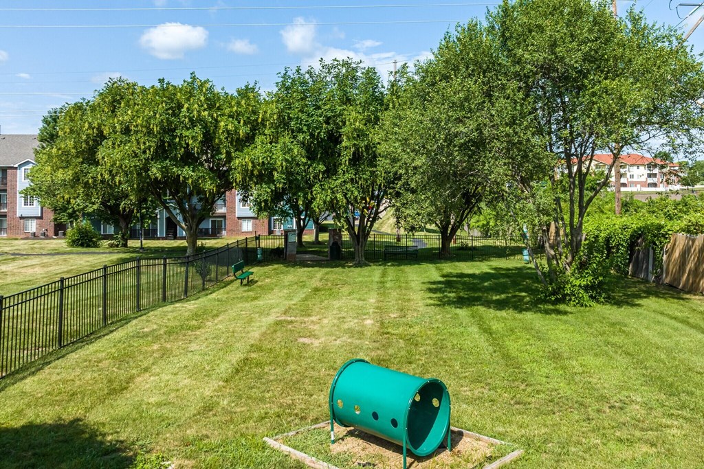 a green park with trees and a green pipe
