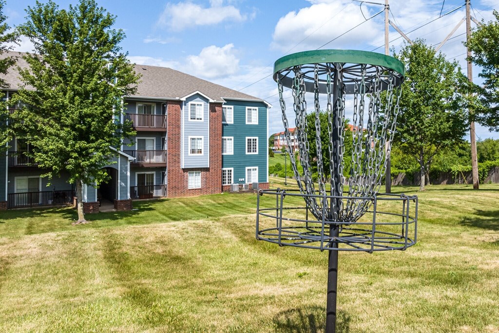 a metal contraption in a yard in front of an apartment building