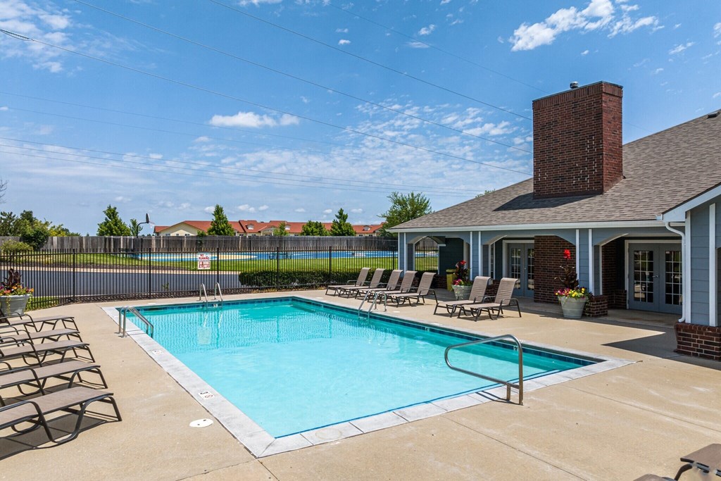 our resort style swimming pool is in front of our house with lounge chairs