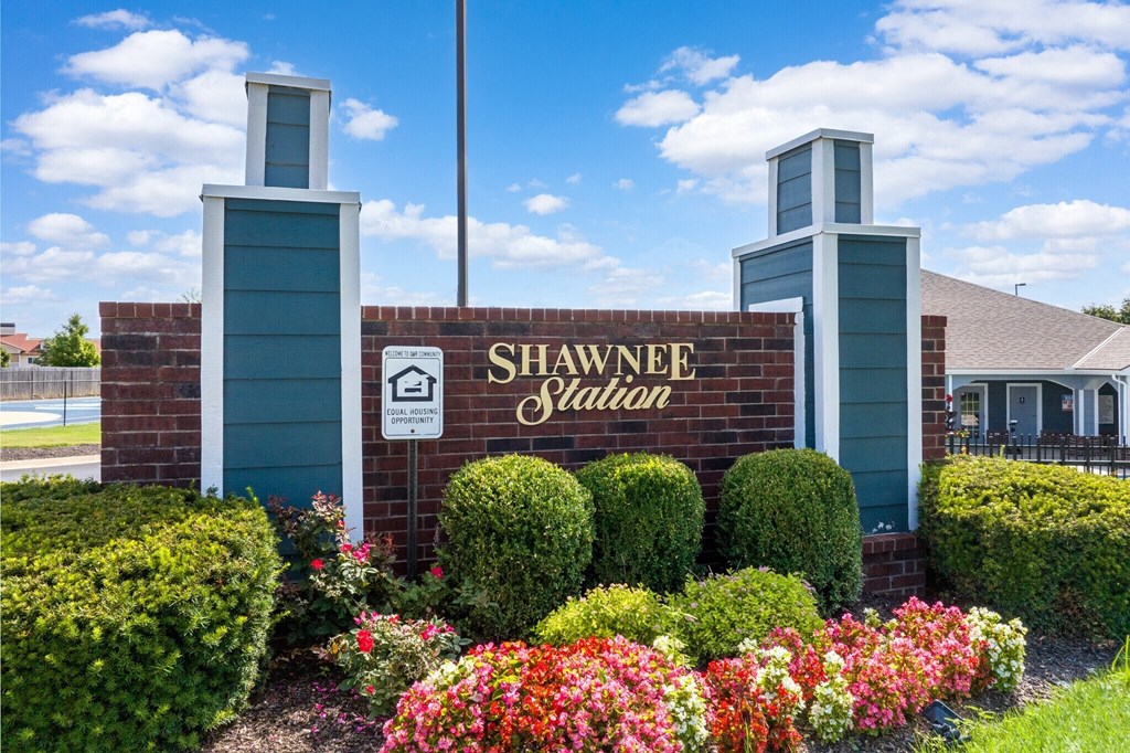 the sign for shawnee village with flowers in front of the building