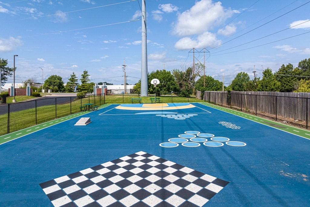a basketball court in a park with a basketball hoop on the ground