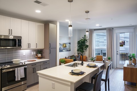 A modern kitchen with a dining table set for two.