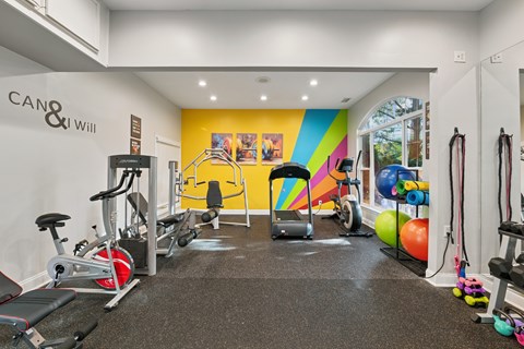 A gym with a variety of equipment including treadmills, weights, and exercise machines.