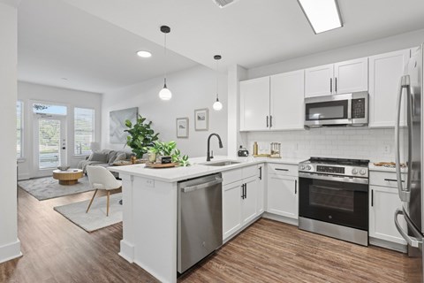 A modern kitchen with white cabinets and stainless steel appliances.