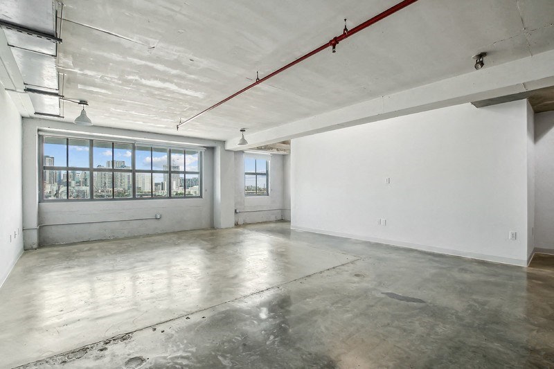 an empty room with white walls and a large window