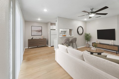 A modern living room with a white sofa and a wooden floor.