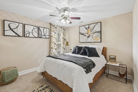 A bedroom with a large bed and a ceiling fan.